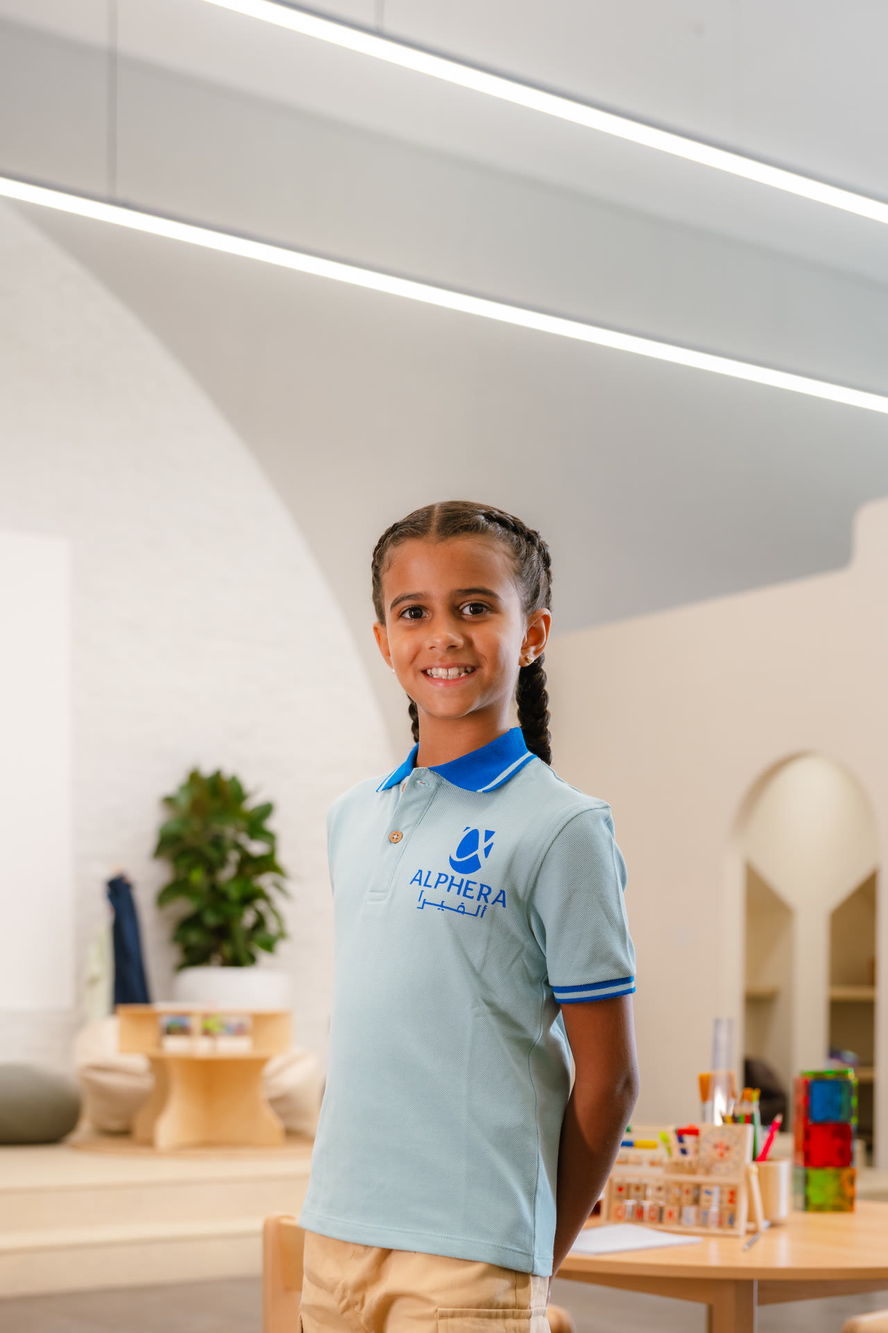 An Alphera learner stands in a classroom.