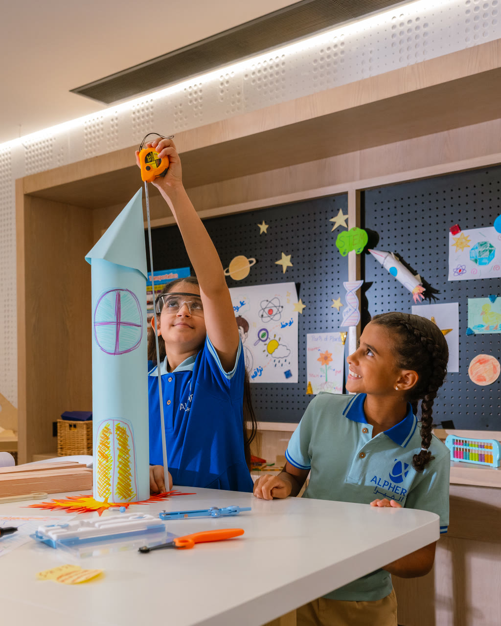 Two learners test a model they built in an Alphera lab.