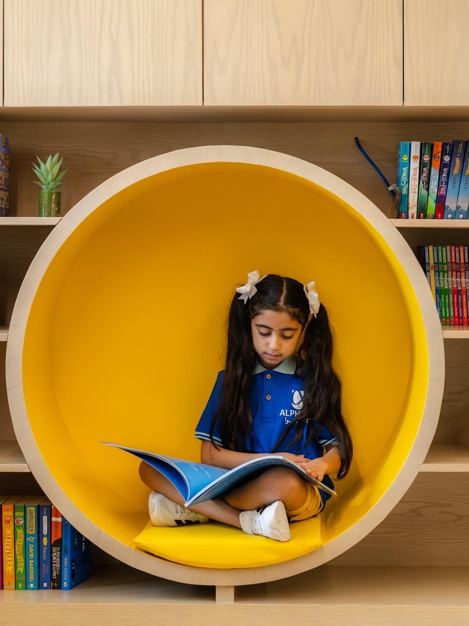 A learner reads inside a circular library nook.