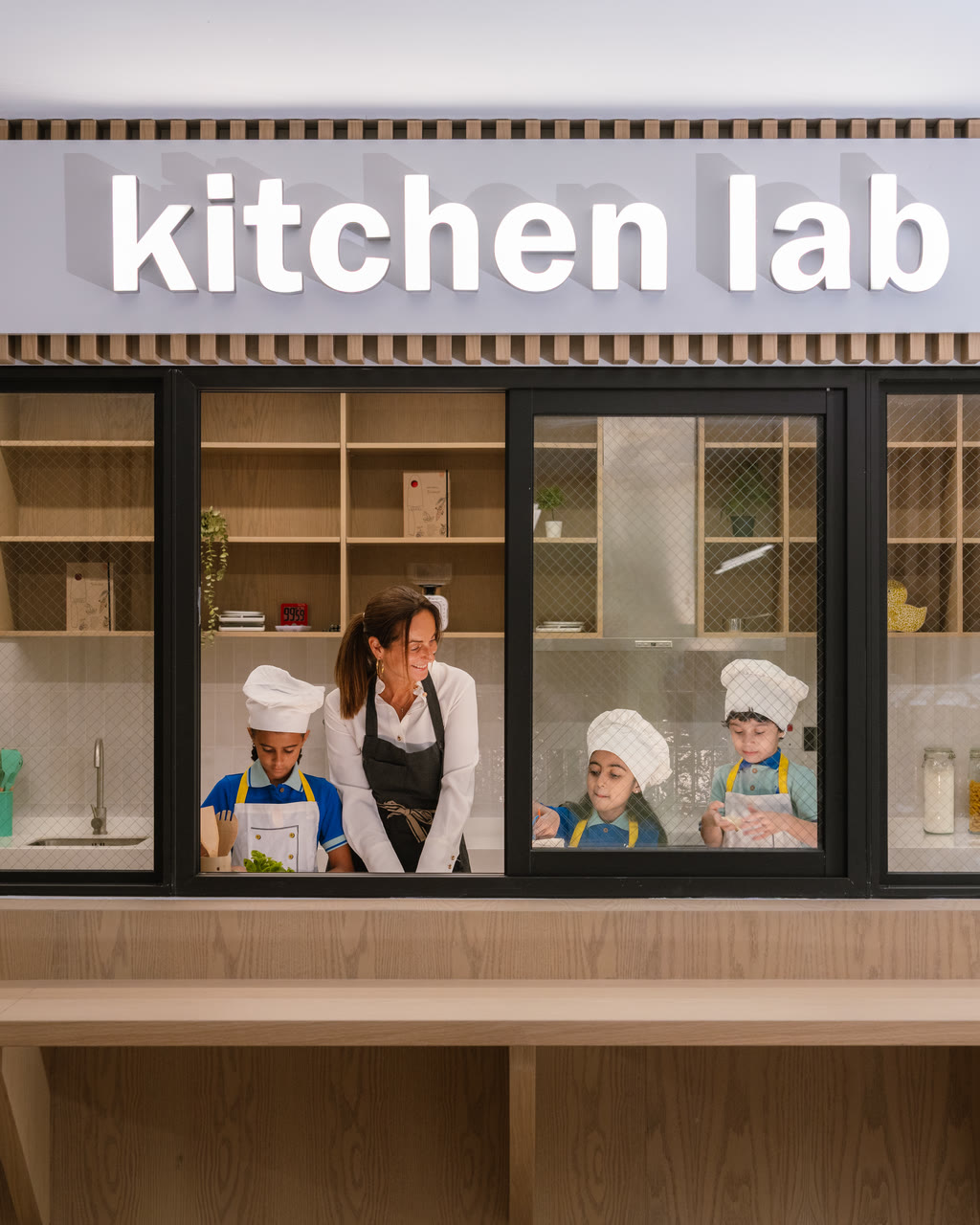 Learners prepare food with an adult in Alphera’s kitchen lab.