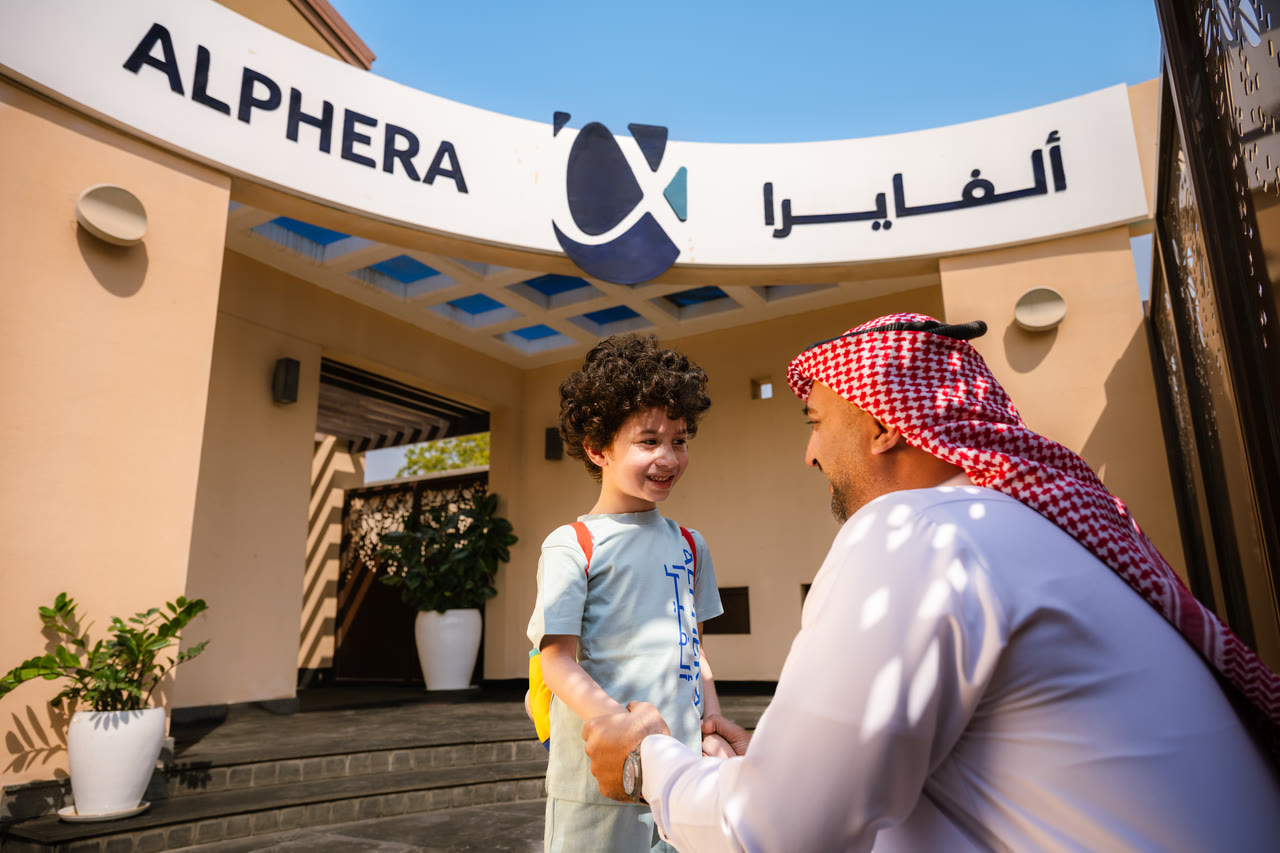 A learner is welcomed at the Alphera entrance.
