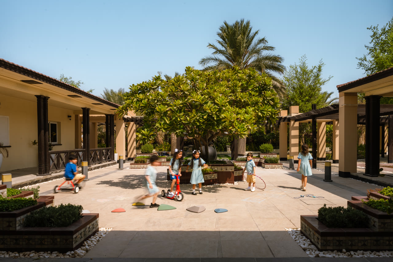 Learners play together in Alphera’s shaded courtyard.